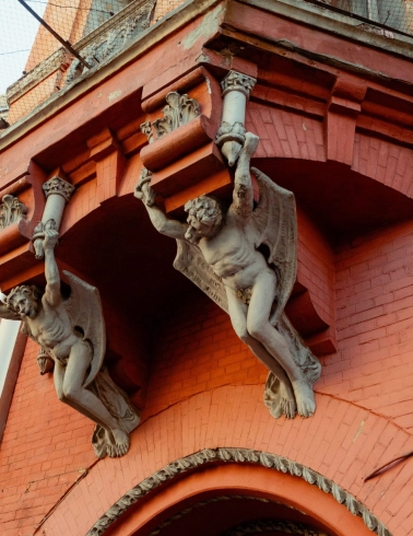 Barons castle in Kyiv - winged stone demons holding the balcony of the red castle