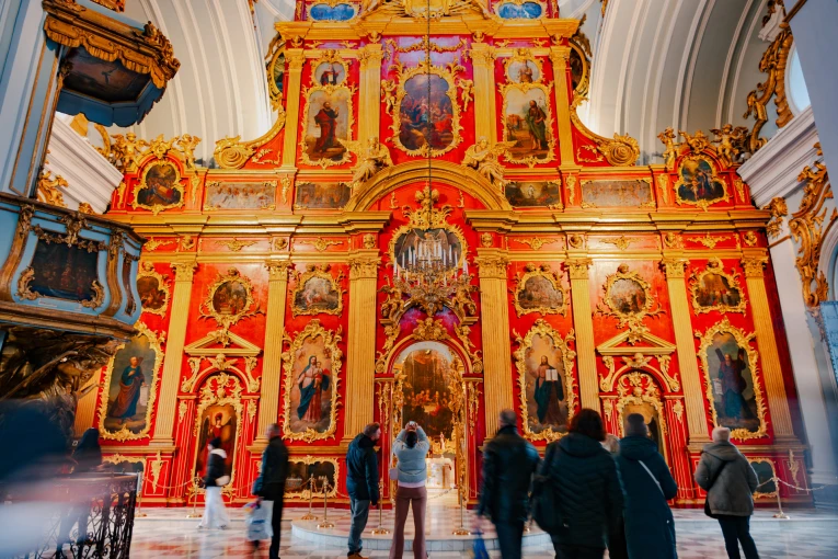 St. Andrew's Church in Kyiv - interior with red iconostasis and visitors