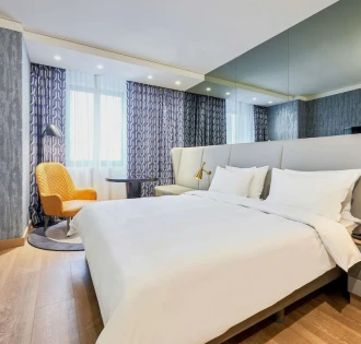 Spacious modern room at the Radisson Blu Hotel in the center of Kyiv with a double bed and a seating area