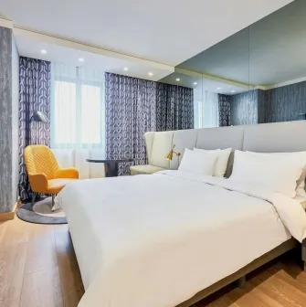 Spacious modern room at the Radisson Blu Hotel in the center of Kyiv with a double bed and a seating area