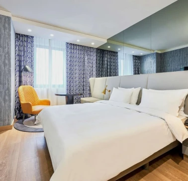 Spacious modern room at the Radisson Blu Hotel in the center of Kyiv with a double bed and a seating area