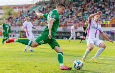 Гравець у зеленій формі завдає удару по м'ячу під час матчу на Оболонь Арені