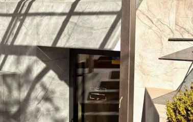 Concept 1 Boutique in Kyiv - entrance to the shop featuring a marble facade and a black sign with the logo above the glass door