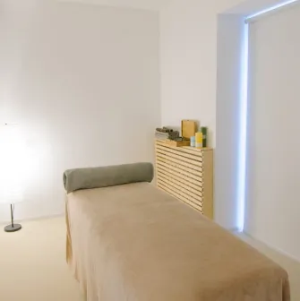 Massage room with couch and lamp in Aura Spa