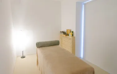 Massage room with couch and lamp in Aura Spa
