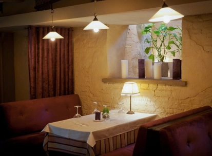 Resraurant Under Wonder - cozy interior with velvet booth seating and dramatic overhead lighting