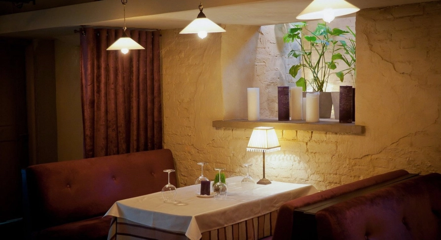 Resraurant Under Wonder - cozy interior with velvet booth seating and dramatic overhead lighting