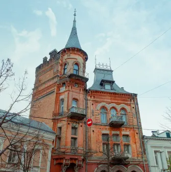 Barons castle in Kyiv - red brick Gothic facade with a high tower and arched windows