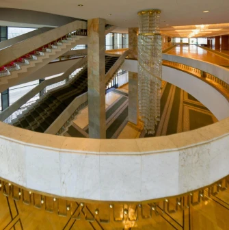 Palats Ukraina in Kyiv - elegant marble spiral staircase wrapping around a massive crystal chandelier in the foyer