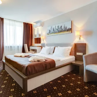 A cozy bedroom with a double bed and a comfortable armchair at the Bratyslava Hotel in Kyiv