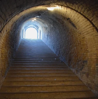 Kyiv Fortress in Kyiv - dark underground brick passage with stairs leading to the light