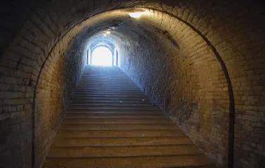 Kyiv Fortress in Kyiv - dark underground brick passage with stairs leading to the light