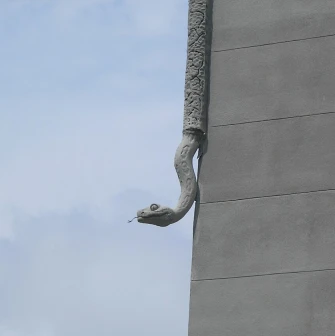 Budynok Horodetskoho in Kyiv - stone python sculpture crawling down the building corner