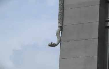 Budynok Horodetskoho in Kyiv - stone python sculpture crawling down the building corner