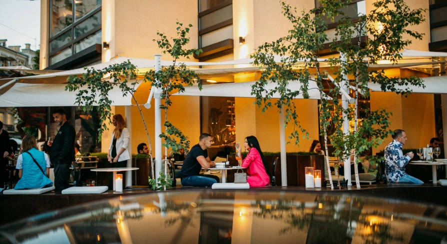 BEEF meat & wine - cozy outdoor terrace with tables and chairs near the railing