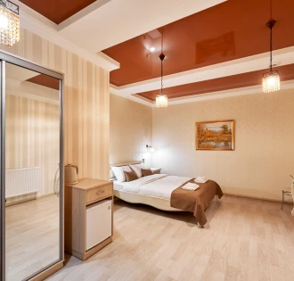 Cozy bedroom in Hotel Classic with a bed, mirror, and small dining set