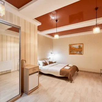 Cozy bedroom in Hotel Classic with a bed, mirror, and small dining set