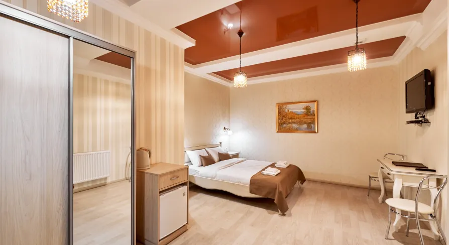 Cozy bedroom in Hotel Classic with a bed, mirror, and small dining set