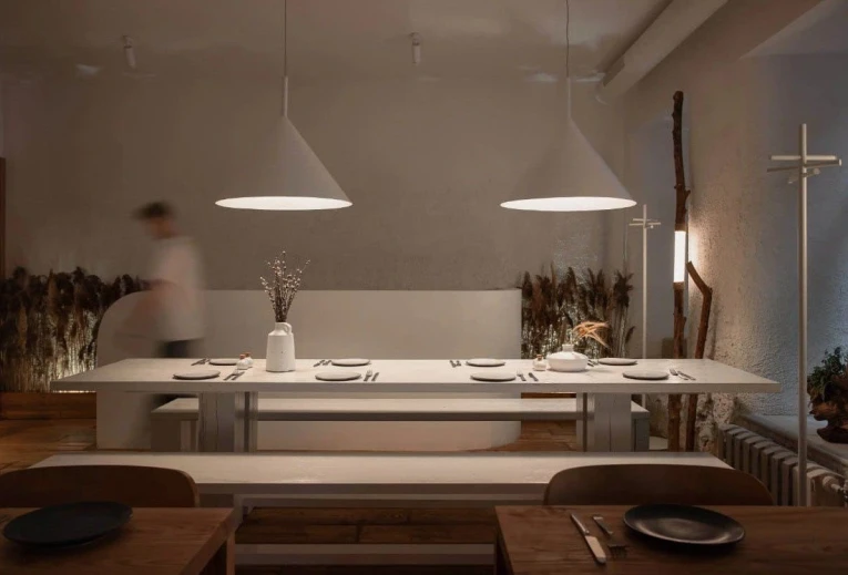 Restaurant 100 Rokiv Tomu Vpered - minimalist dining area with a long white communal table