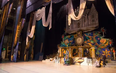 National Opera of Ukraine in Kyiv - atmospheric stage setting for a performance featuring large elegant drapes, a clock, and a festive Christmas tree
