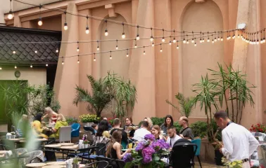 Restaurant Italiets iz Beiruta - people dining outdoors on a patio decorated with plants and string lights