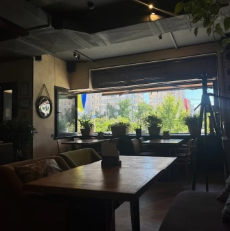 Chachapuri in Kyiv - dining hall interior with large open window and plants