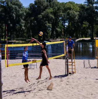 X-Park in Kyiv - active game of beach volleyball on a sandy court near the water