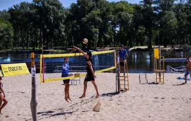 X-Park in Kyiv - active game of beach volleyball on a sandy court near the water