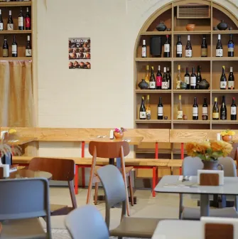 Restaurant Poltava - dining area with wooden benches and shelves stocked with wine bottles