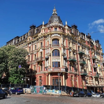 Volodymyrska Street in Kyiv - elaborate corner building with a dome and rich red and yellow facade decorations