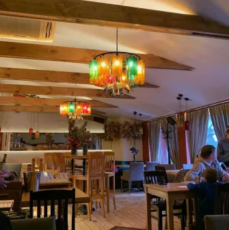 Restaurant Mama Focaccia & Papa Chacha - cozy interior with wooden beams and colorful bottle chandeliers