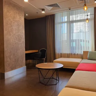 Ibis Kyiv City Center in Kyiv - lounge area with beige sofa, round table and window