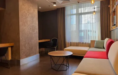 Ibis Kyiv City Center in Kyiv - lounge area with beige sofa, round table and window