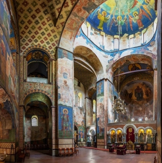 St. Cyril's Church in Kyiv- spacious nave with painted dome, chandelier and red floor