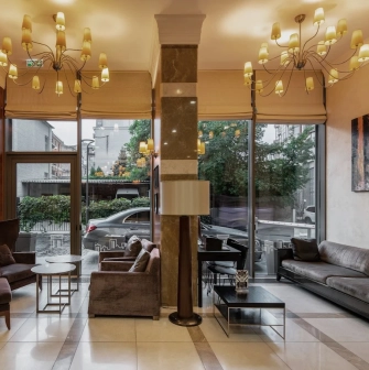 City Hotel in Kyiv - lobby lounge with chandeliers, sofas and large windows to street